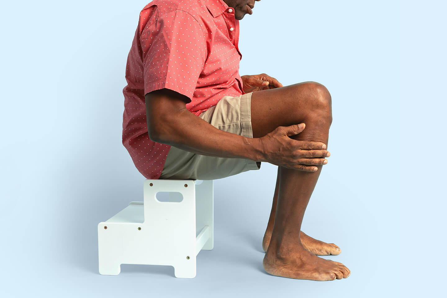 man sitting holding his legs