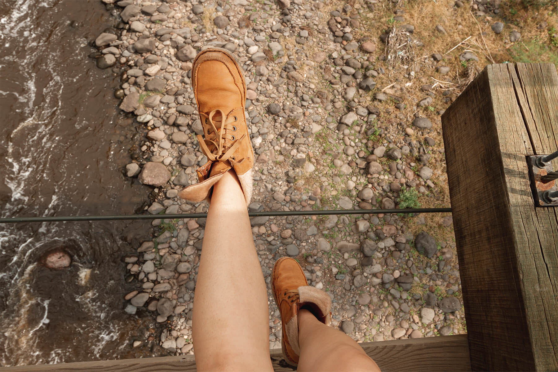 legs hanging over a rocky stream in Austin, TX